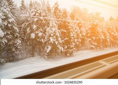 Beautiful snow-covered forest is visible from the window of a traveling train - Powered by Shutterstock