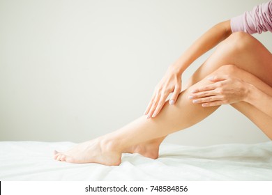 Beautiful Soft Skin. Closeup Of Long Woman Legs With Perfect Hairless Smooth And Silky Skin, Woman's Hand Touhing Her Sexy Slender Leg