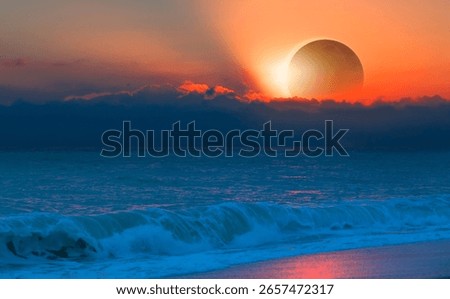 Beautiful solar eclipse with dramatic clouds over the ocean waves at sunset