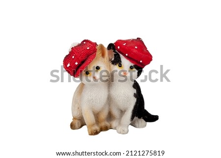 Beautiful souvenir kittens. in a little red riding hood. the toys are made of porcelain. ceramics. and plaster. with rhinestones. On an isolated white background. close-up.