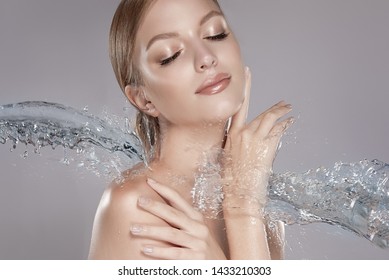 Beautiful spa woman with water splashes. Moisturizing facial skin, beauty and care.