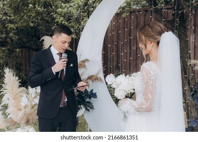 Beautiful Space Wedding Ceremony In The Summer Of A Chic Couple, The Groom In A Suit And The Bride In A White Luxurious Wedding Dress.