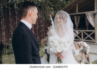 Beautiful Space Wedding Ceremony In The Summer Of A Chic Couple, The Groom In A Suit And The Bride In A White Luxurious Wedding Dress.