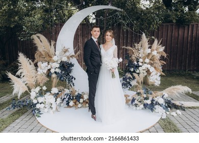 Beautiful Space Wedding Ceremony In The Summer Of A Chic Couple, The Groom In A Suit And The Bride In A White Luxurious Wedding Dress.