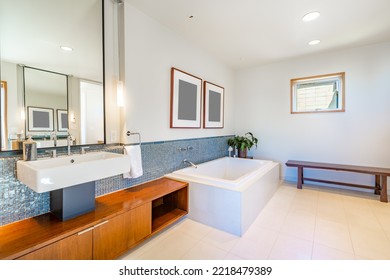 beautiful spacious white and blue bathroom with square freestanding bathtub mosaic tile wall mounted sinks glass shower stall and marble floors - Powered by Shutterstock