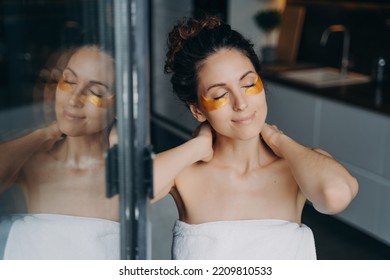 Beautiful Spanish Young Woman With Under Eye Hydrogel Patches On Face Touching Her Neck After Shower. Happy Girl Closed Eyes Enjoying Morning Beauty Routine At Home. Skincare, Self Love, Self-care.