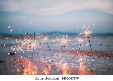 Beautiful sparklers on the beach in the sunset light with blurred background. - Powered by Shutterstock