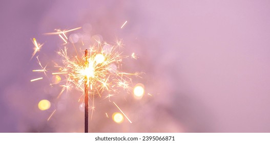 Beautiful sparkles from sparklers on the background of New Year's bokeh, Christmas mood, glitter, festive background. Bright fire on a pink background.