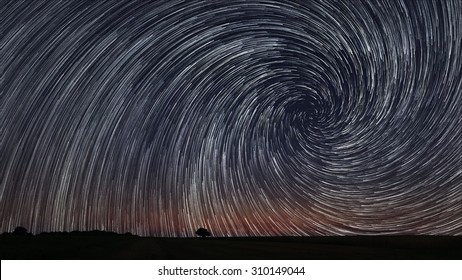 Beautiful Spiral Star Trails Over Filed With Lonely Tree. Beautiful Night Sky.
Vortex Star Trails