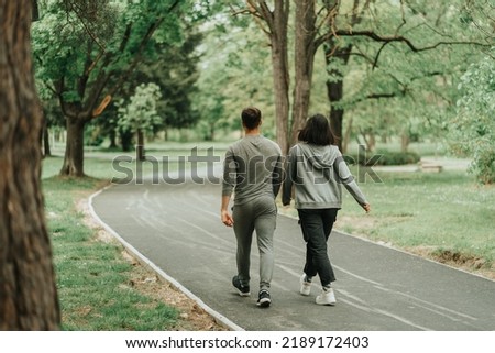 Beautiful sport couple walking on the path in the park