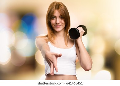 Beautiful Sport Woman With Dumbbells Making A Deal On Unfocused Background