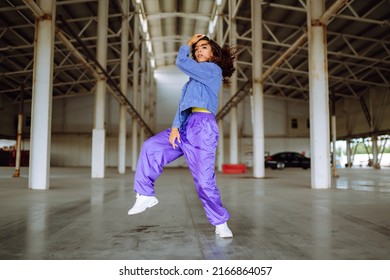 Beautiful sportive girl dancing  in stylish clothes in the underpass. Sport, dancing and urban culture concept. - Powered by Shutterstock