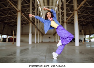Beautiful sportive girl dancing  in stylish clothes in the underpass. Sport, dancing and urban culture concept.