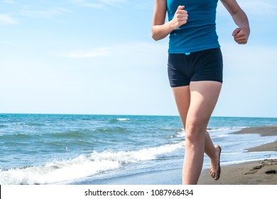 Beautiful sportive girl running along beautiful sandy beach, healthy lifestyle.