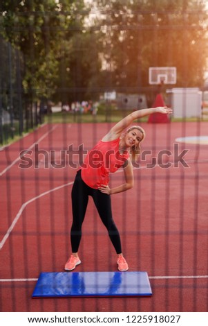 Similar – Young woman stretching legs before training outdoors