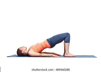 Beautiful sporty fit yogini woman practices yoga asana setu bandhasana - bridge pose beginner variation in studio isolated on white