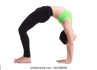 Beautiful sporty girl doing fitness workout, exercise bridge, asana urdhva dhanurasana, Upward Bow (Wheel) yoga Pose, training for strong back and shoulder muscles