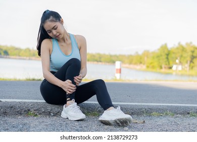 Beautiful Sporty Girl Sad With Leg Pain After Outdoor Jogging Sports Injuries, Calves, Legs, Muscle Pain During Training Asian Female Runners Have Problems After Running And Exercising Outdoors.