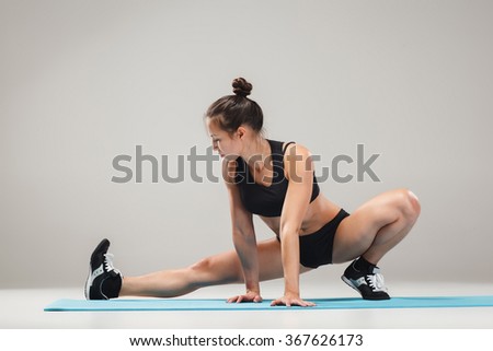 Beautiful sporty girl standing in acrobat pose or yoga asana
