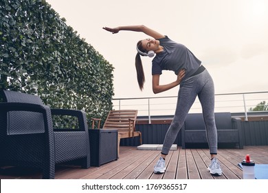 Beautiful Sporty Lady Enjoying Listening To Music And Working Out At Rooftop Lounge