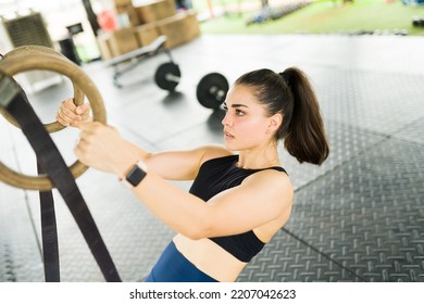 Beautiful Sporty Woman Looking Determined While Using Rings During Her Trx Training And Doing Row Back Exercises