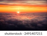 A beautiful spring sunset above the clouds flying over the Baltic Sea. Travel wonderlust scenery.