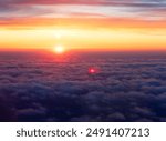 A beautiful spring sunset above the clouds flying over the Baltic Sea. Travel wonderlust scenery.