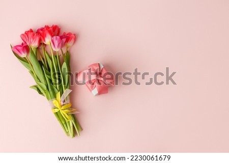 Beautiful spring surprise on Mothers or Womans International day 8 march, Wedding, Saint Valentine. Bouquet of pink tulips, gift box on pink table. Flat lay, stylish banner for site, seasonal flyer
