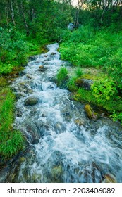 Beautiful Stormy Mountain River Of Emerald And Blue Hues Runs Over Rocks Top View