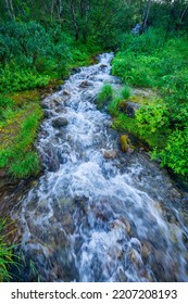 Beautiful Stormy Mountain River Of Emerald And Blue Hues Runs Over Rocks Top View