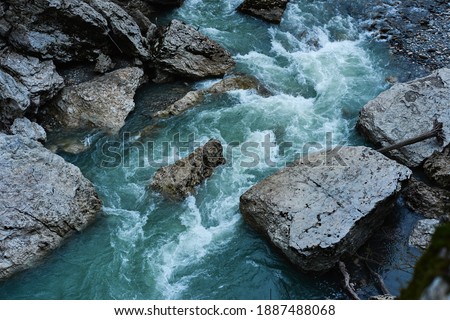Beautiful stormy mountain river of emerald and blue hues runs over rocks top view. Wild and beautiful nature of Caucasian reserve, river Belaya, Republic of Adygea, Russia.