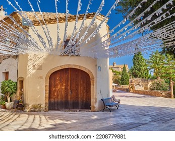 Beautiful Street In Alcudia Old Town Decorated With White Garlands. Medieval Town In Majorca, Balearic Islands, Spain, Europe. Mediterranean Culture