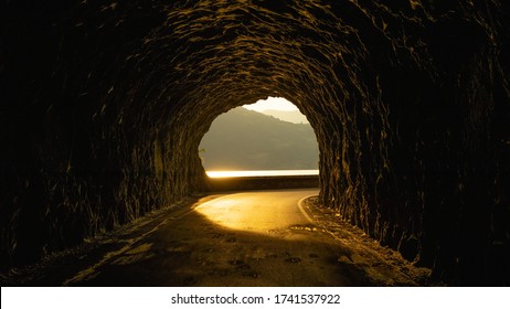 beautiful street in a rocky tunnel with an amazing sunset. 
this is a street near an italian lake. - Powered by Shutterstock