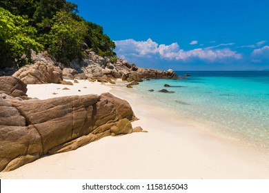 Beautiful stretch of a fine soft white sandy beach, turquoise blue shimmering water, big rocks & lush trees which belongs to Rawa Island, a popular snorkeling spot near Perhentian Kecil in Malaysia. 
