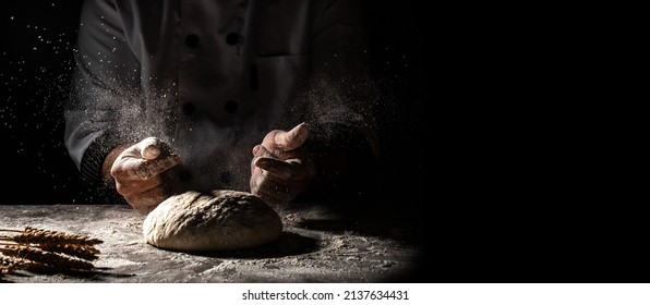 Beautiful and strong men's hands knead the dough from which they will then make bread, pasta or pizza. A cloud of flour flies around like dust. Food concept, Long banner format, - Powered by Shutterstock