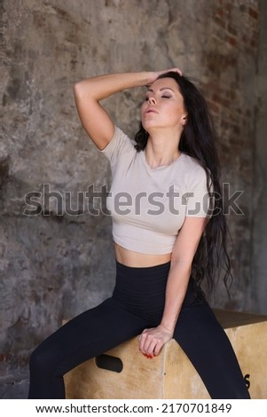 beautiful strong muscular woman in gym. Healthy middle-aged adult woman in sportswear. Fit thin girl doing sports indoors, training hard. Woman having rest after sports