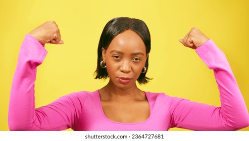 Beautiful strong woman flexes both arms, muscle, yellow studio background - Shutterstock ID 2364727681