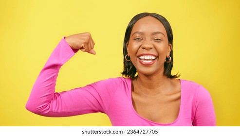 Beautiful strong woman flexes one arm, muscle, yellow studio background - Shutterstock ID 2364727705