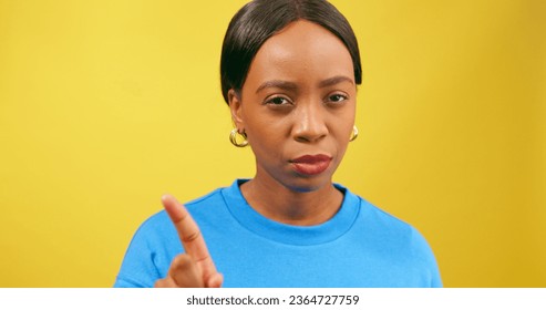 Beautiful strong woman gestures No with finger, shakes head, yellow studio - Shutterstock ID 2364727759