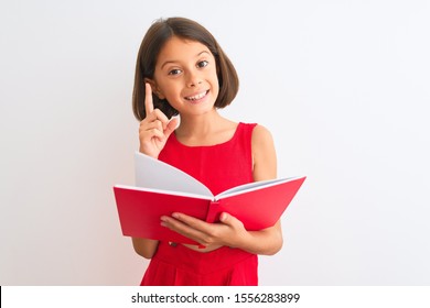 Beautiful Student Child Girl Reading Red Book Standing Over Isolated White Background Surprised With An Idea Or Question Pointing Finger With Happy Face, Number One