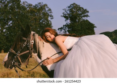 Beautiful and stunning bride, riding a horse in the nature, on her wedding day