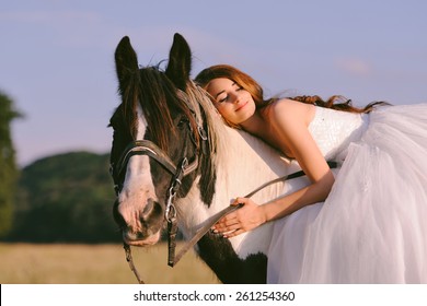 Beautiful and stunning bride, sleeping on a horse in the nature, on her wedding day