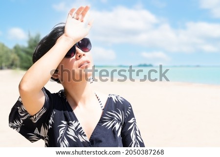 A beautiful stylish asian woman on the beach wearing 100% UV sunglasses to protect her eyes and face from sun exposure. Skin aging, Optical, Ultraviolet keratitis, Skincare, SPF, Beauty, Copy space.