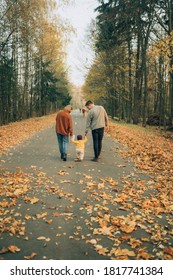 Beautiful And Stylish Family Walking In The Autumn Forest