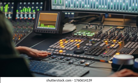 Beautiful, Stylish Female Audio Engineer and Producer Working in Music Recording Studio, Uses Mixing Board to Create Cool Song. Creative Girl Artist Musician Working. Back View Shot. - Powered by Shutterstock