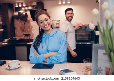 Beautiful Stylish Female Barista Standing At Cafe Counter And Smiling. Cafeteria Worker. Portrait.