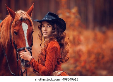 Beautiful Stylish Girl In A Cowboy Hat With A Horse Walking In The Autumn Forest, Country Style