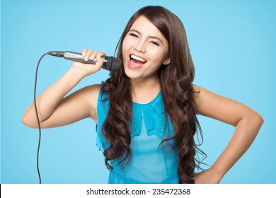 beautiful stylish woman singing karaoke isolated over blue background - Powered by Shutterstock