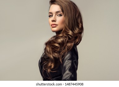 Beautiful stylish woman wearing  black leather jacket. Fashionable and self-confident girl with long curly hair. Clothing, style and fashion