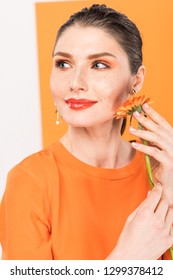 Beautiful Stylish Young Woman Holding Flower And Posing With Tumeric On Background